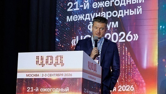 Выступающий у трибуны с логотипом форума рассказывает залу о развитии дата-центров