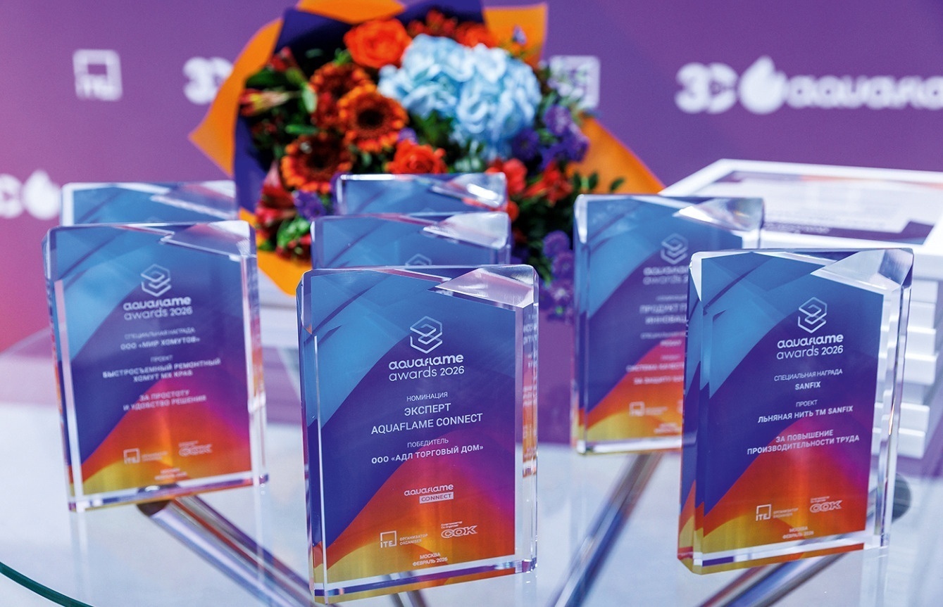 Стеклянные награды премии Aquaflame Awards с цветными логотипами на столе рядом с букетом цветов
