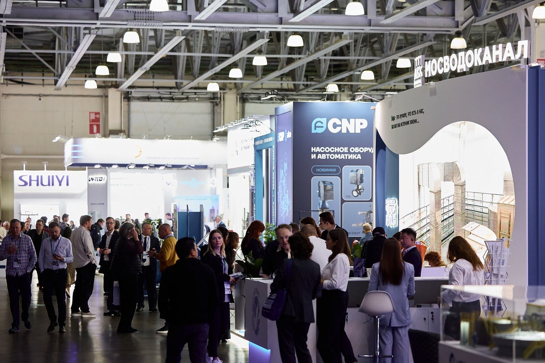 Главный проход павильона ЭКВАТЭК 2026 со стендами CNP и Мосводоканала, в проходе много посетителей
